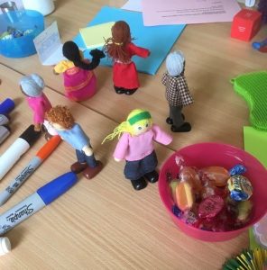 Table with dolls sweets and pens on ready for a facilitation